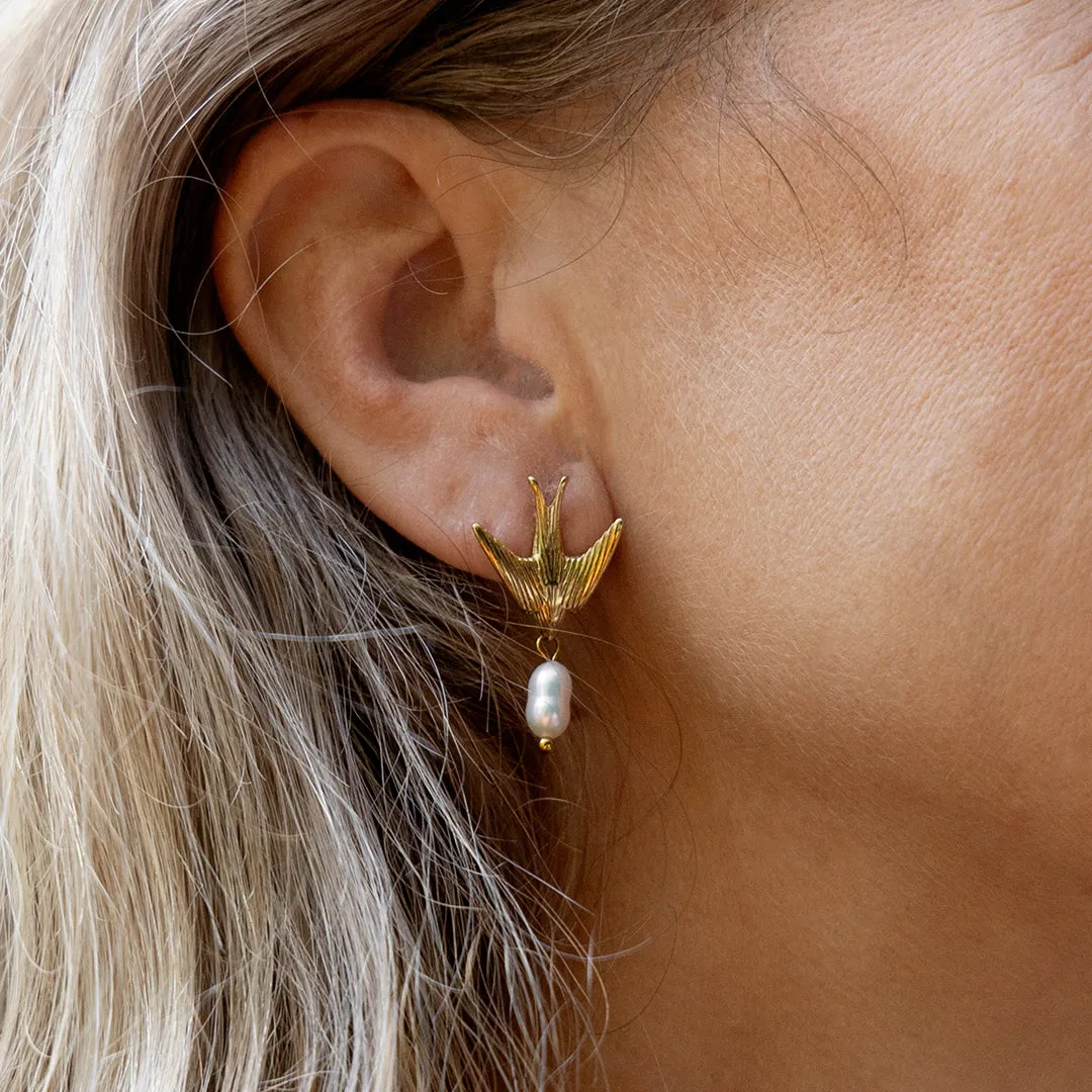 Gold coloured/white stud earring with a swallow